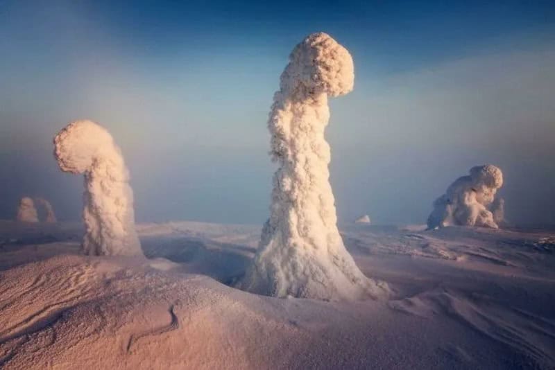 Strange snow formations resembling figures in a snowy landscape.