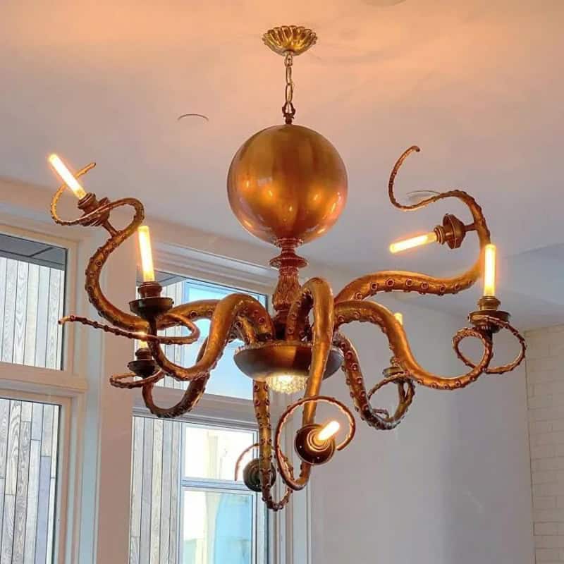 Unique chandelier with tentacle-like arms and exposed bulbs in a modern room.