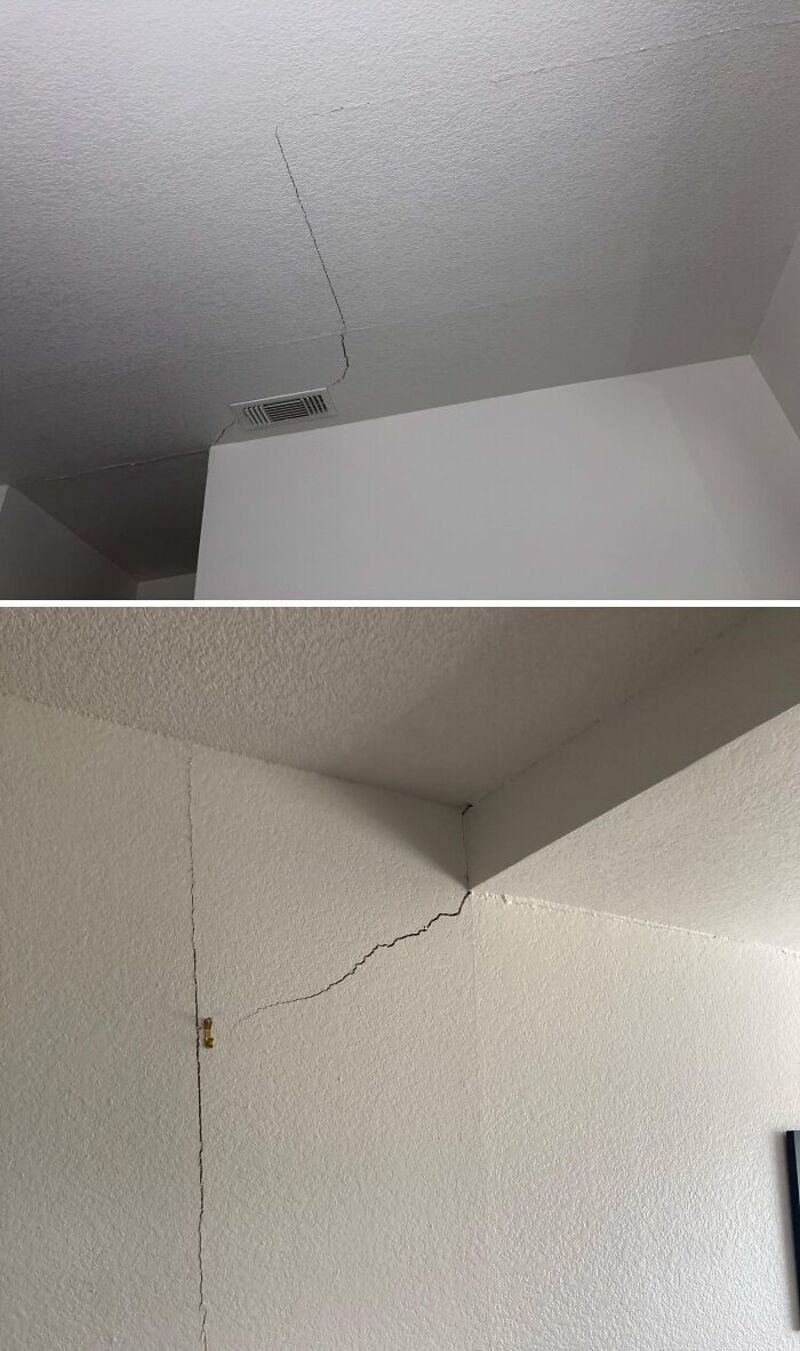 Cracks in the ceiling and wall of a room, showing damage.