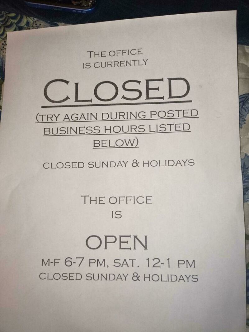 Sign indicating office is closed and open with specific hours.