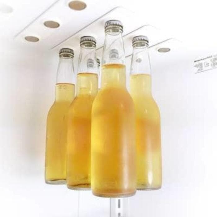 Four bottles of yellow beverage hanging from the ceiling.