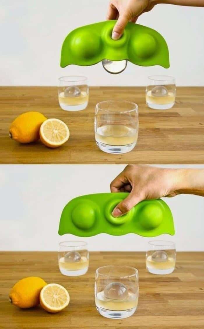 Innovative green gadget with two suction cups, squeezing a lemon into water.