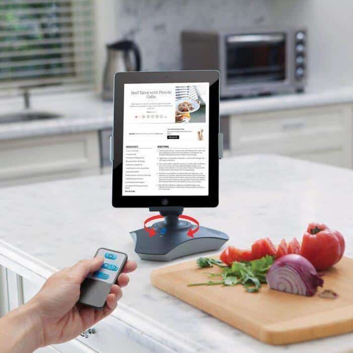Smart kitchen device with remote control on a kitchen counter with vegetables.