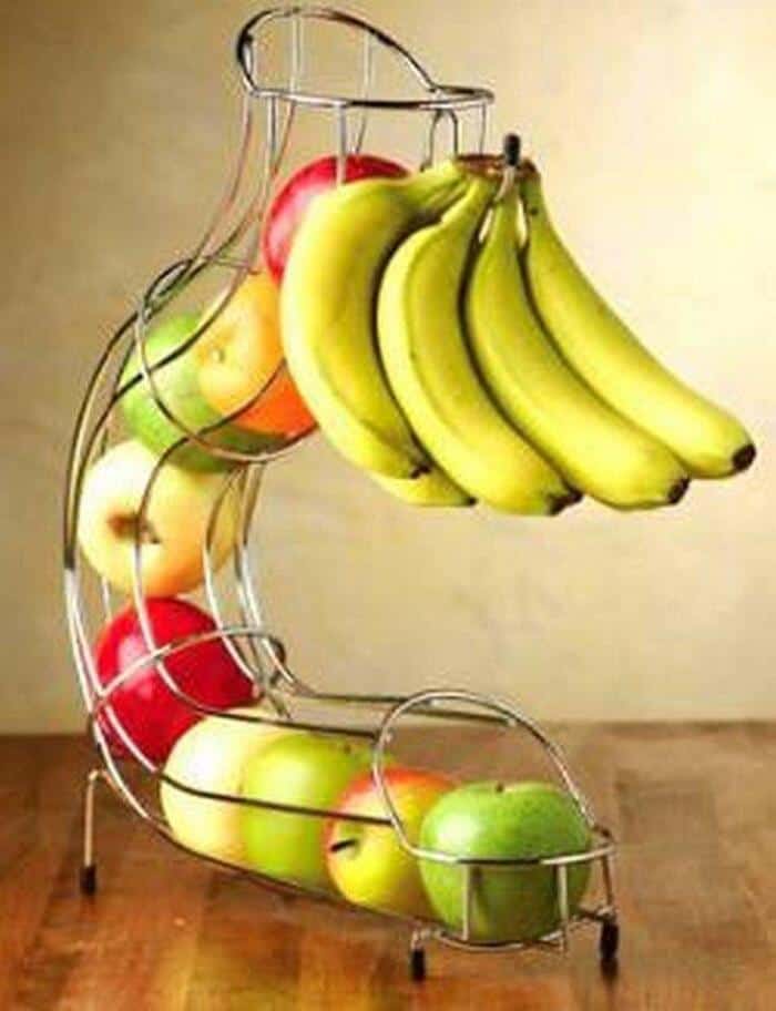 Fruit basket with bananas, apples, and oranges on a metal stand.