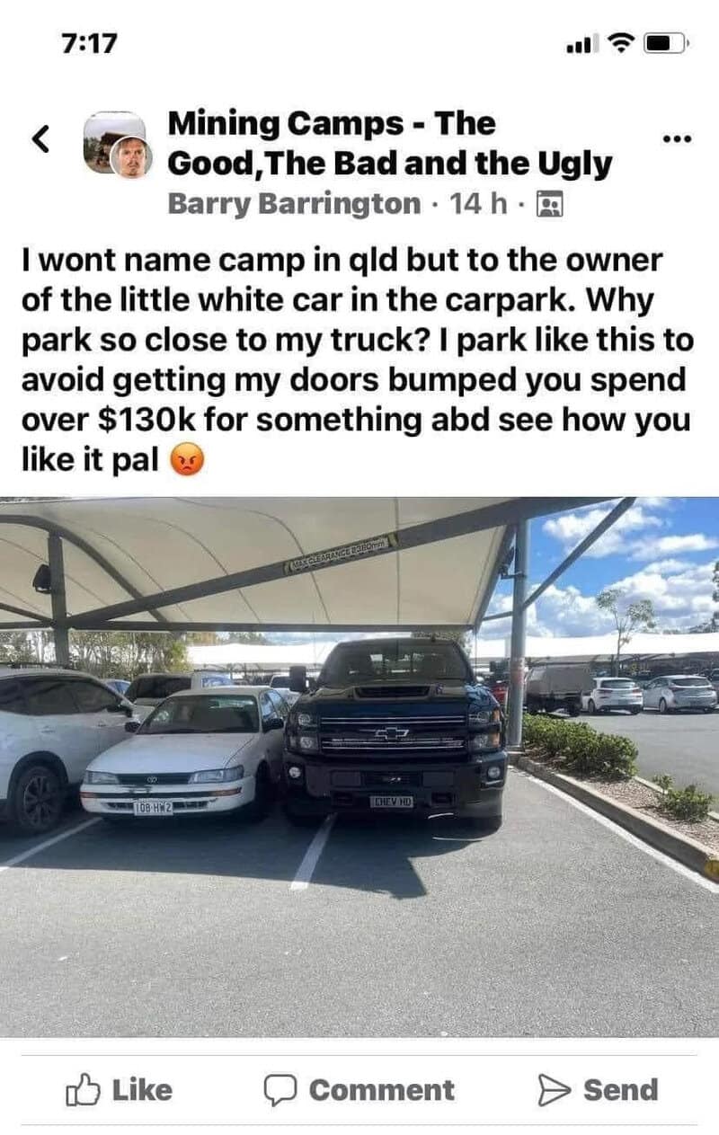 Parking lot with cars under a canopy, including a white car and a black truck.
