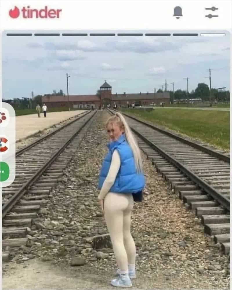 Young woman with long blonde hair in a blue vest and white leggings on train tracks.