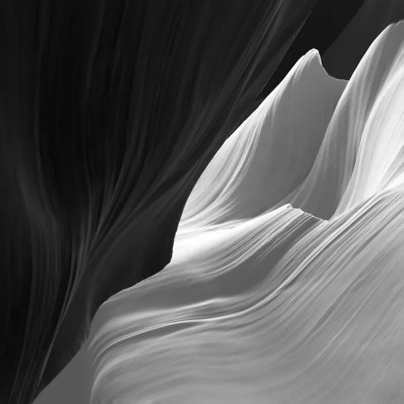 Black and white abstract canyon landscape with smooth flowing lines.