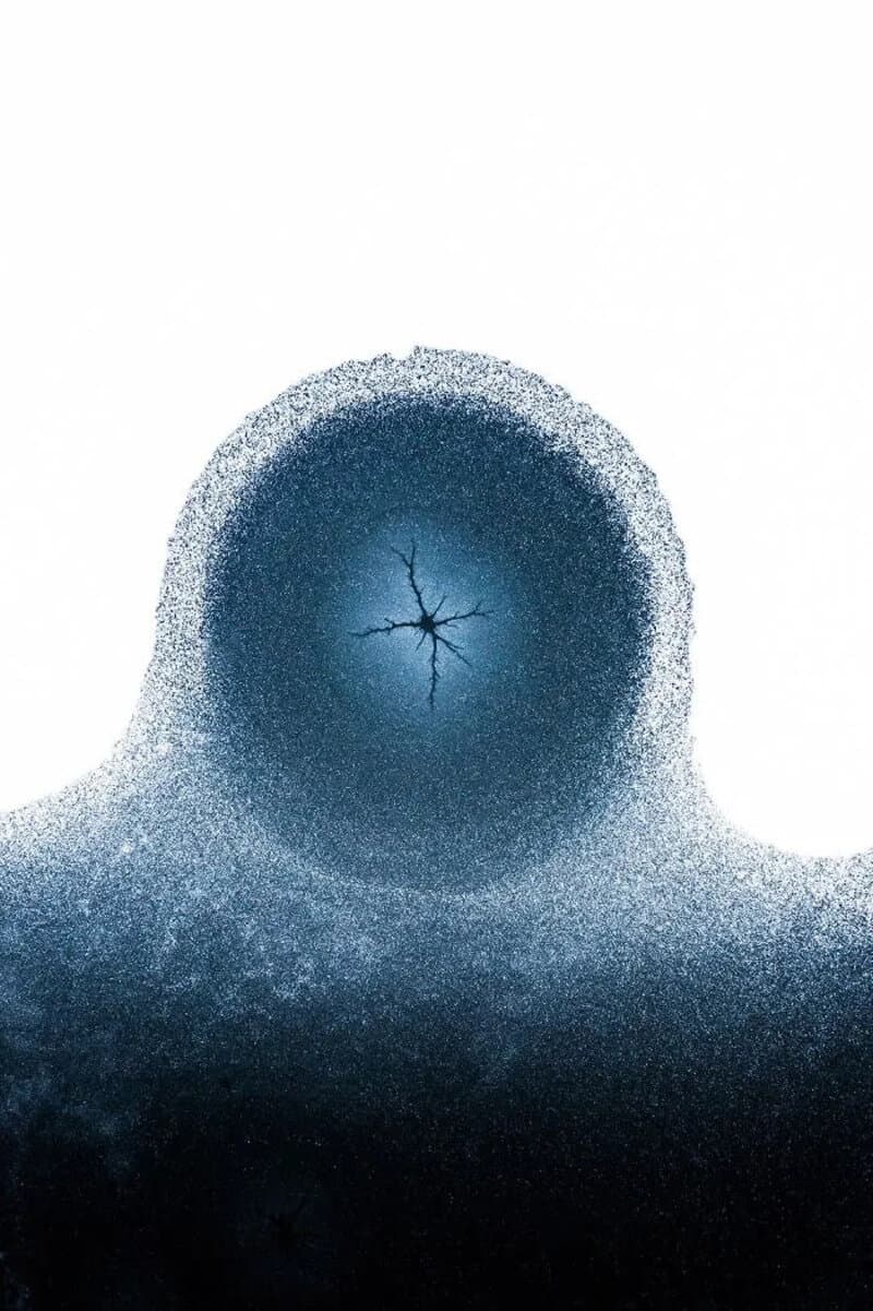 Close-up of a frozen bubble with a crack in the center.