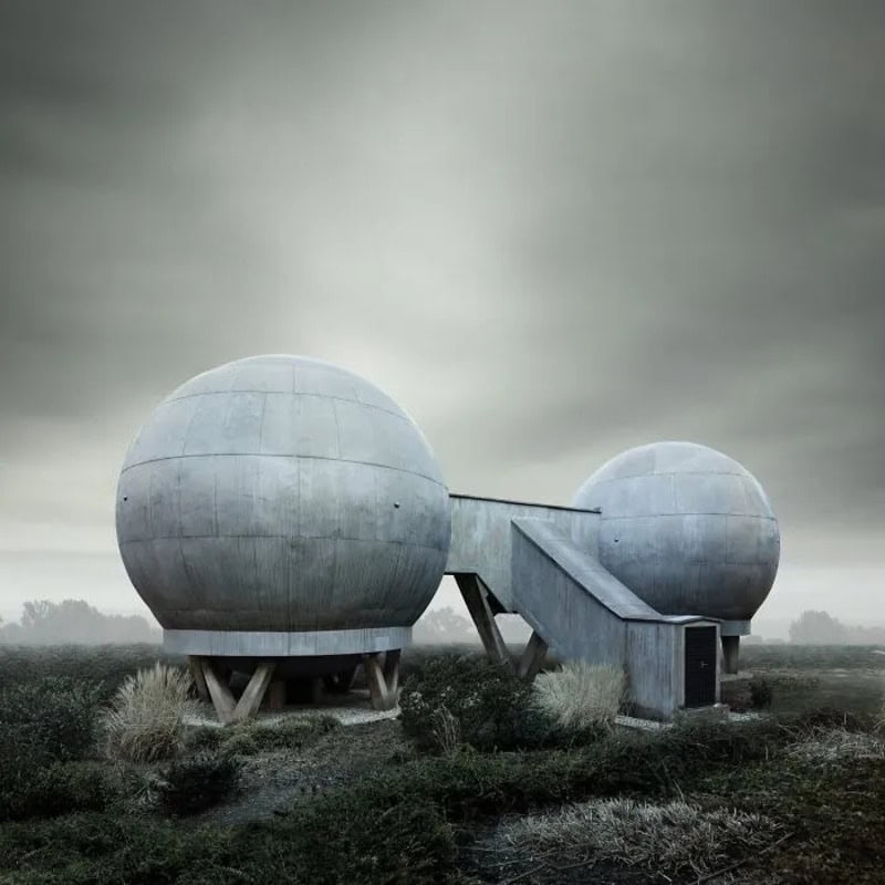 Futuristic concrete structures with spherical shapes and a connecting bridge.