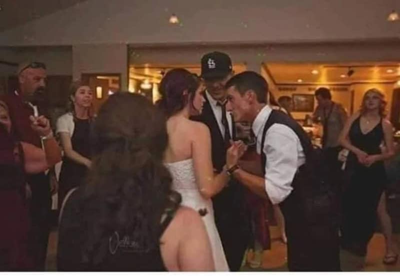 People at a social event, some are talking and others are observing.