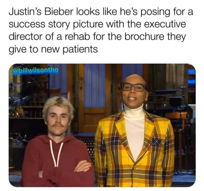 Justin Bieber poses with a man in a yellow plaid jacket in a studio.