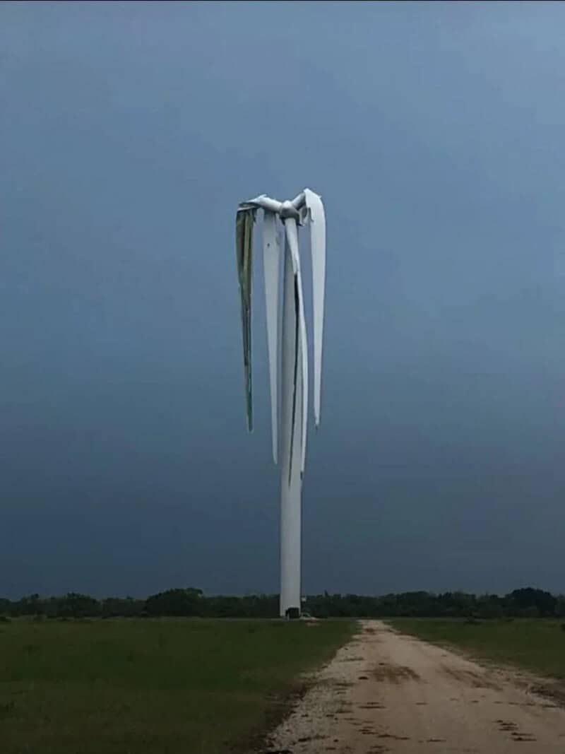 Wind turbine blades appear to be melting or dripping in the sky.