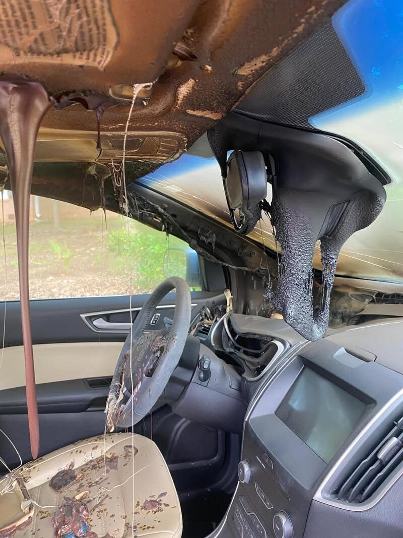 Flooded car interior with water pouring from the ceiling and dashboard.