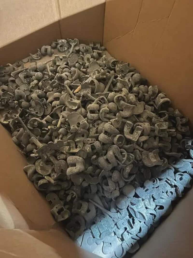 A box filled with numerous small, gray, plastic clips or fasteners.