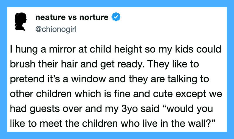 Child at child height hanging a mirror, talking to imaginary children in the wall.