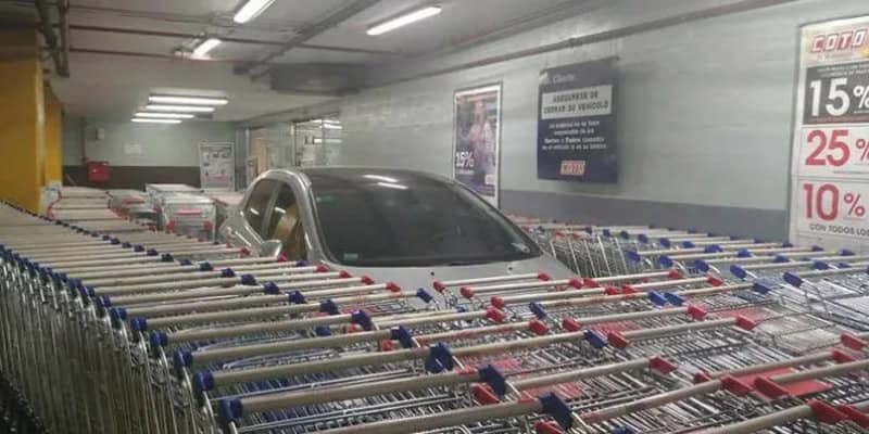 Car parked in a shopping cart corral, surrounded by shopping carts.