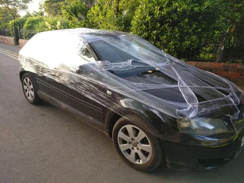 Car wrapped in plastic wrap with a 'petty revenge' caption.
