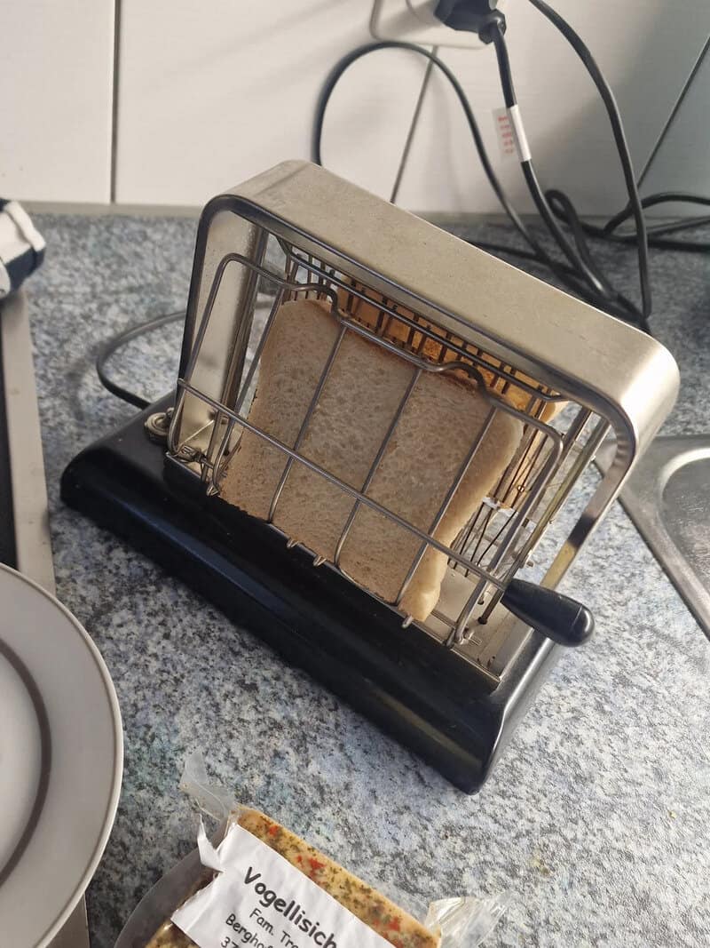 Vintage toaster with bread slices on a kitchen counter.
