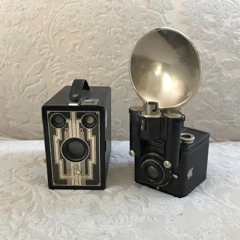 Vintage camera and flash unit on lace fabric, 20th-century style.
