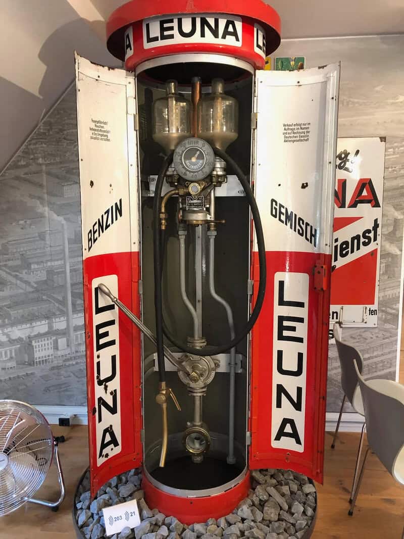 Vintage gas pump with open doors, displaying internal mechanisms, from early 20th century.