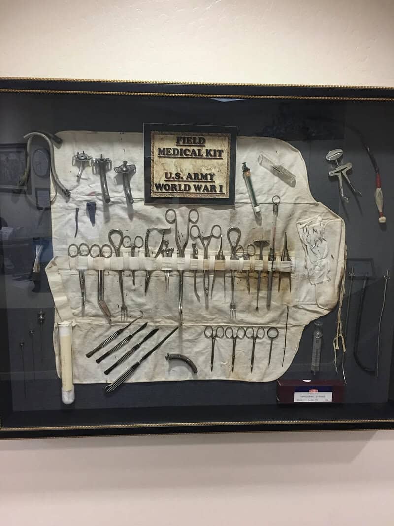 Vintage medical tools and a sign reading 'Field Medical Kit U.S. Army World War I'.