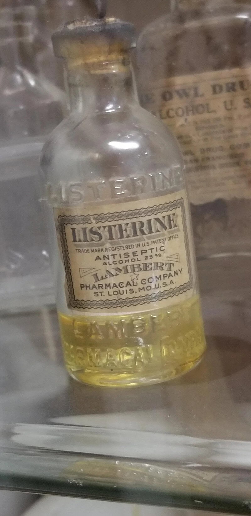 Vintage Listerine bottle with yellow liquid, early 20th century.