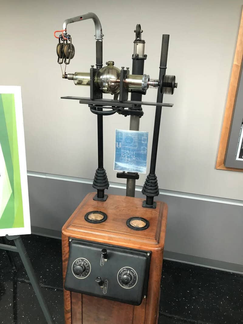 Early 20th-century scientific instrument with dials and glass components on a wooden base.