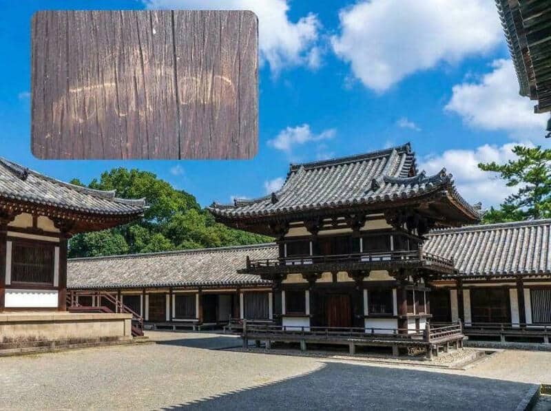 Traditional Japanese temple with wooden structures and tiled roofs under a blue sky.