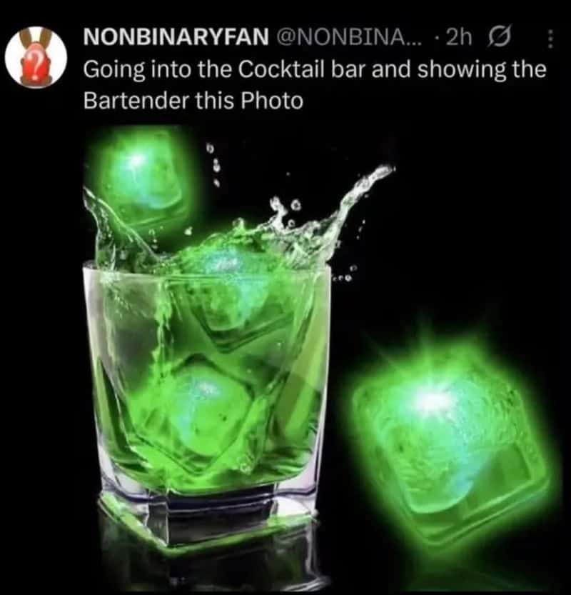 Green glowing ice cubes in a glass with splash, glowing ice cube outside glass.