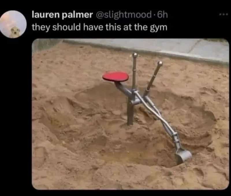 A playground digging tool with a red seat and two metal handles in a sandbox.