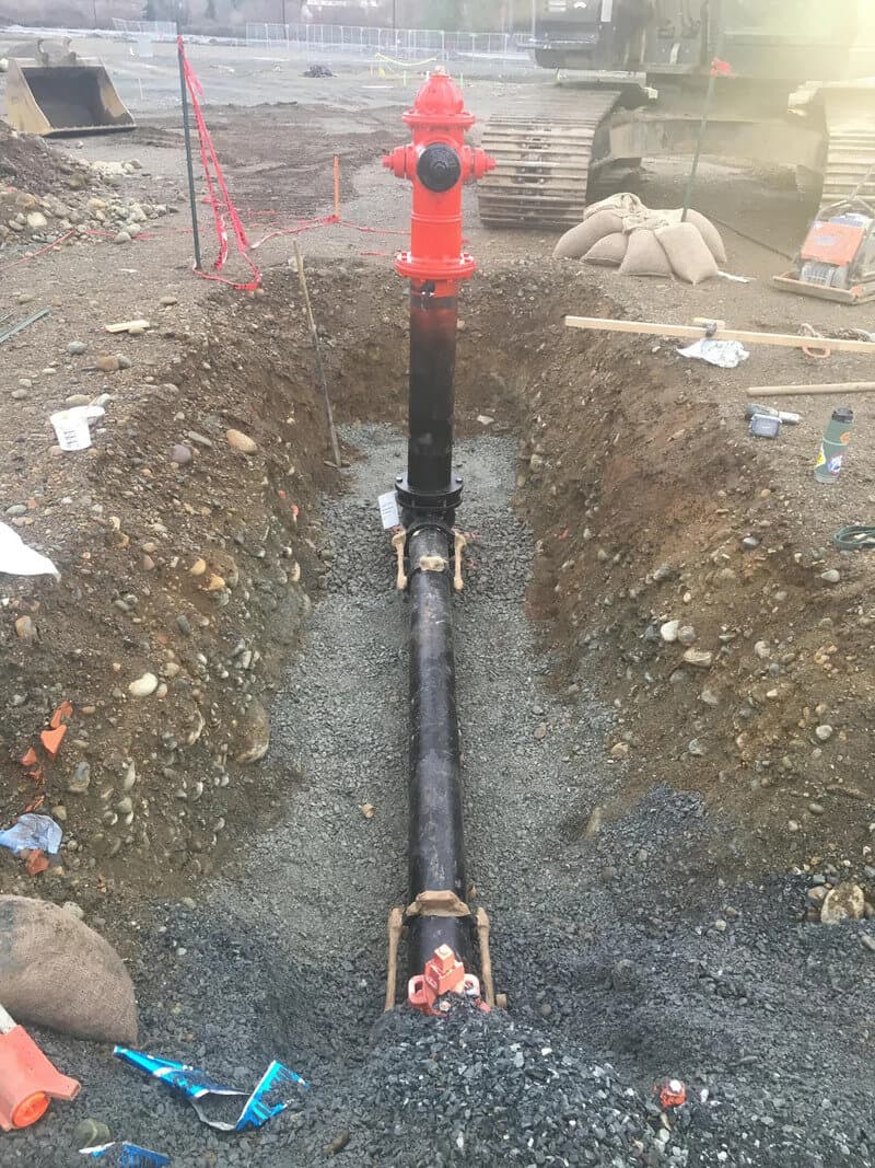 Fire hydrant connected to underground pipe in a construction site.