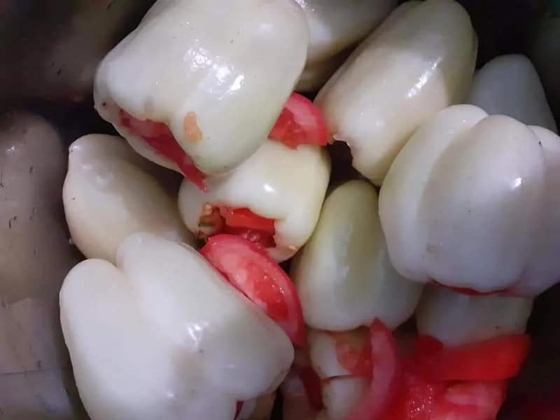 Close-up of white and red bell peppers with some cut open.