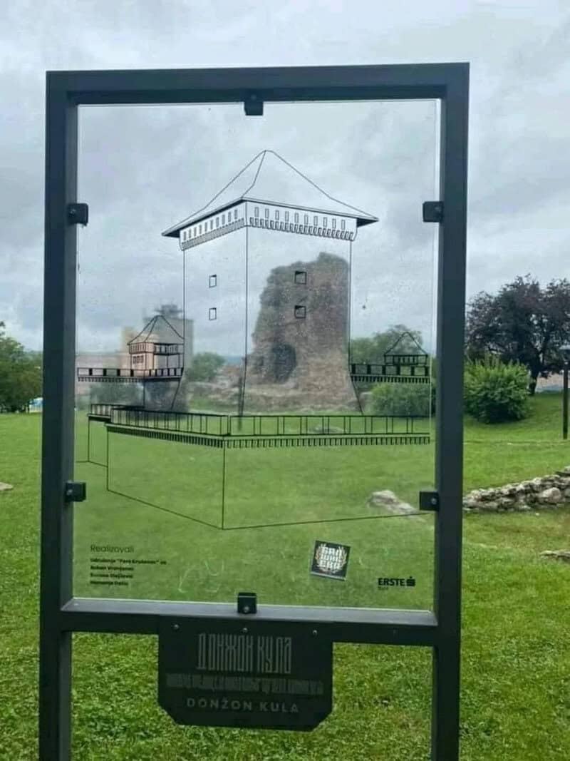 Glass display case showing a 3D illusion of a castle tower and landscape.