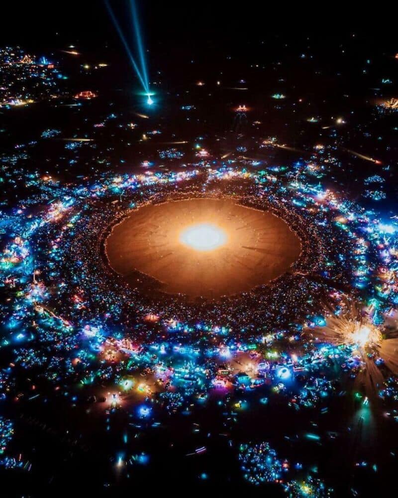 Bright lights surround a large, glowing central area at night.