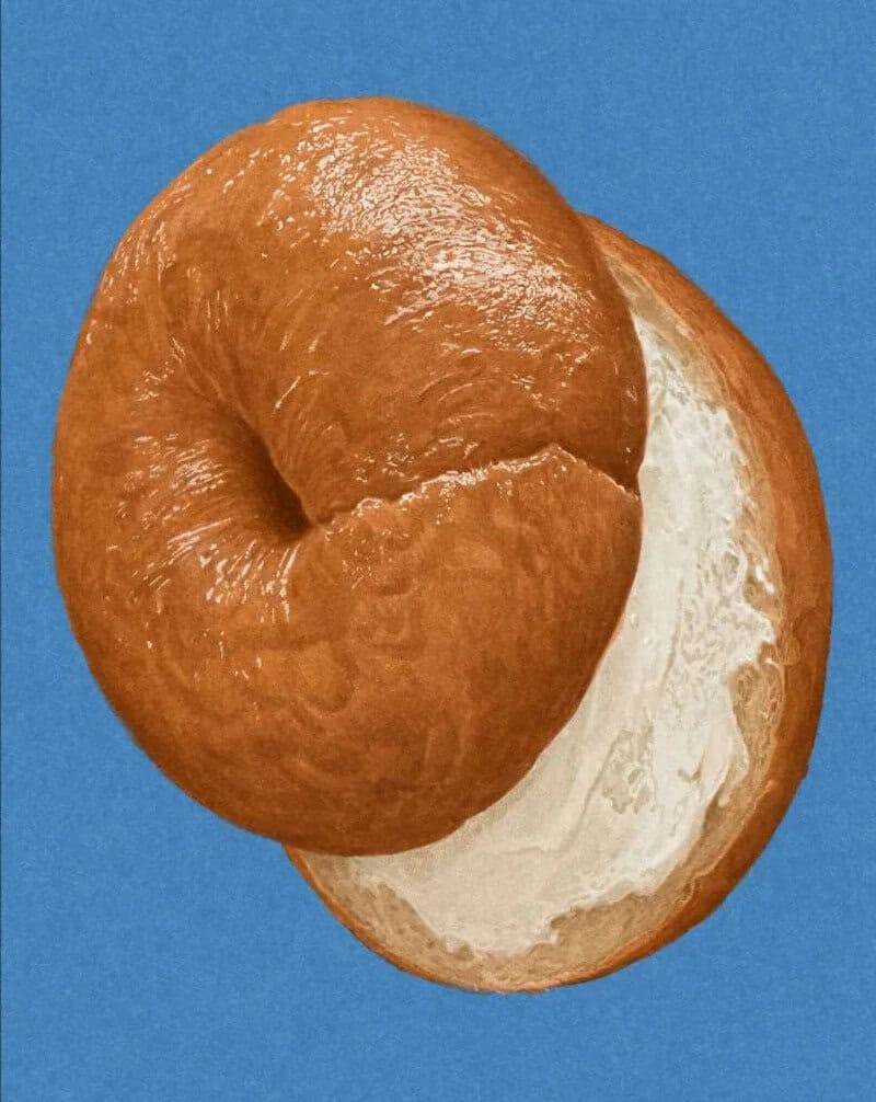 Close-up of a bread roll with a bite taken out, against a blue background.
