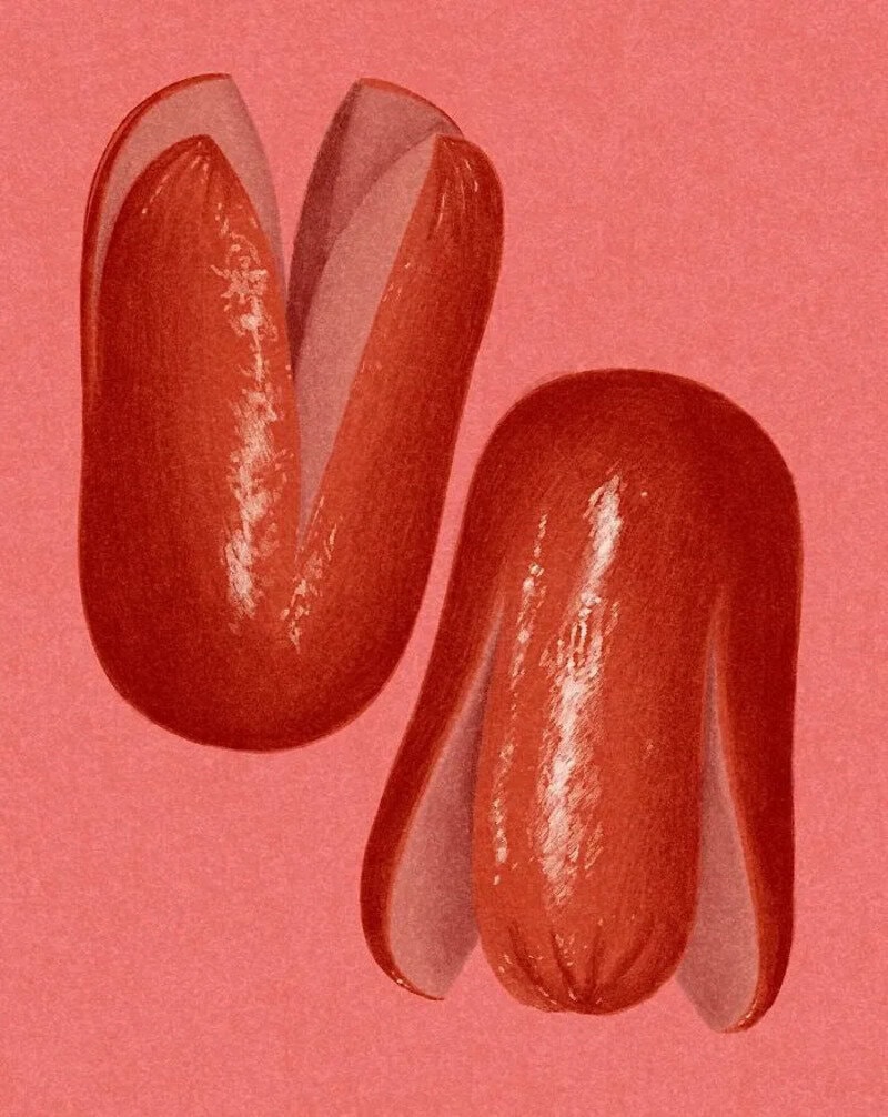Two red chili peppers with one sliced open, on a pink background.
