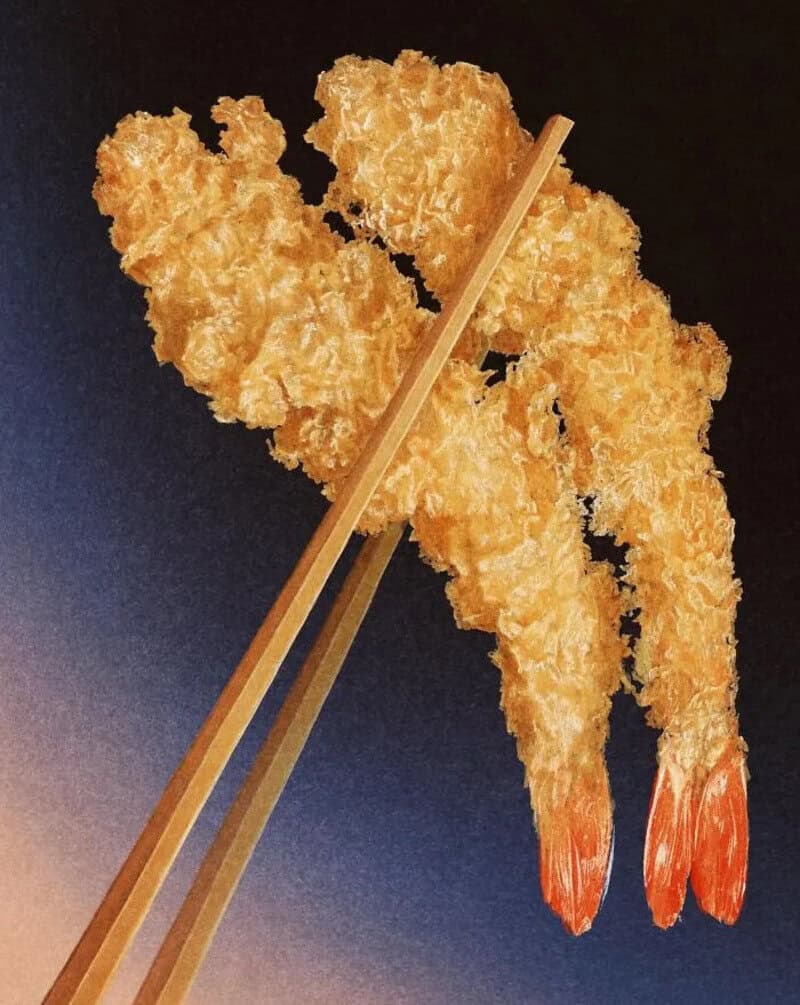 Two fried shrimp with chopsticks on a black background.