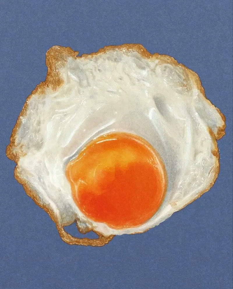 Fried egg with a runny yolk on a blue background.