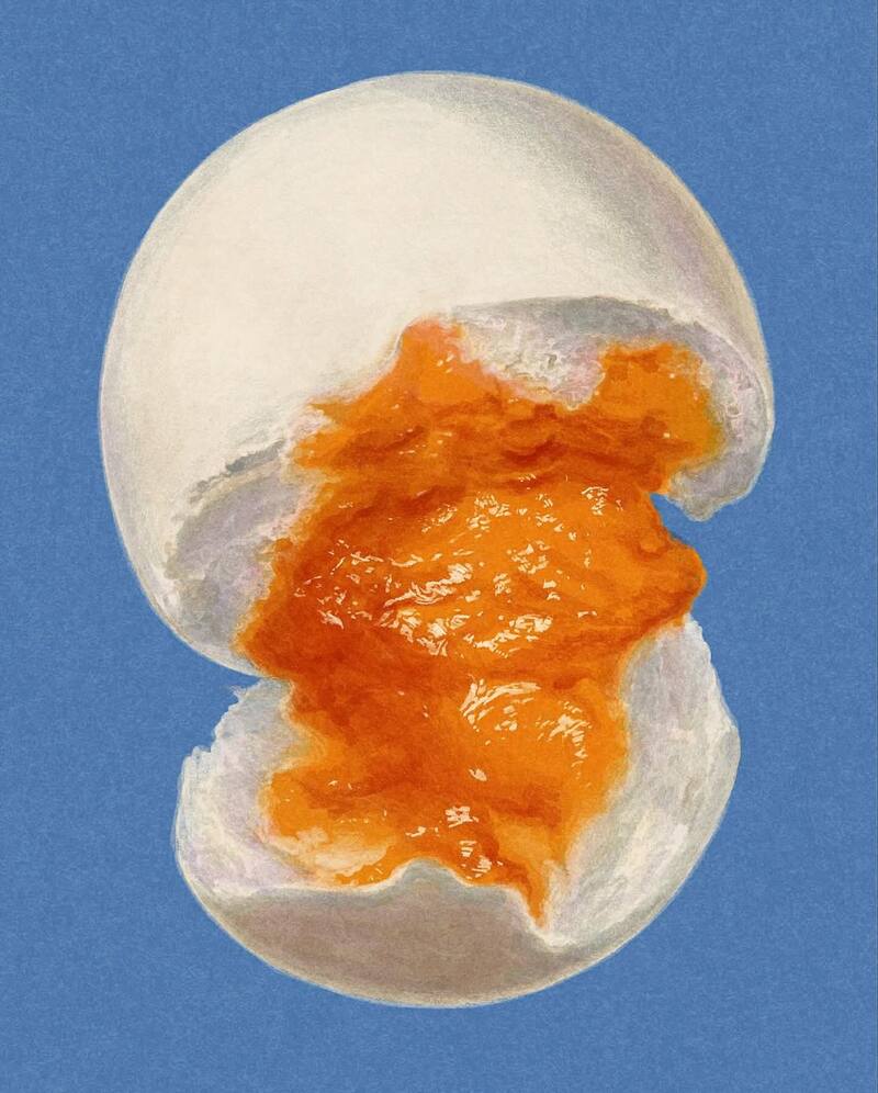 A soft-boiled egg cut in half with bright orange yolk on a blue background.
