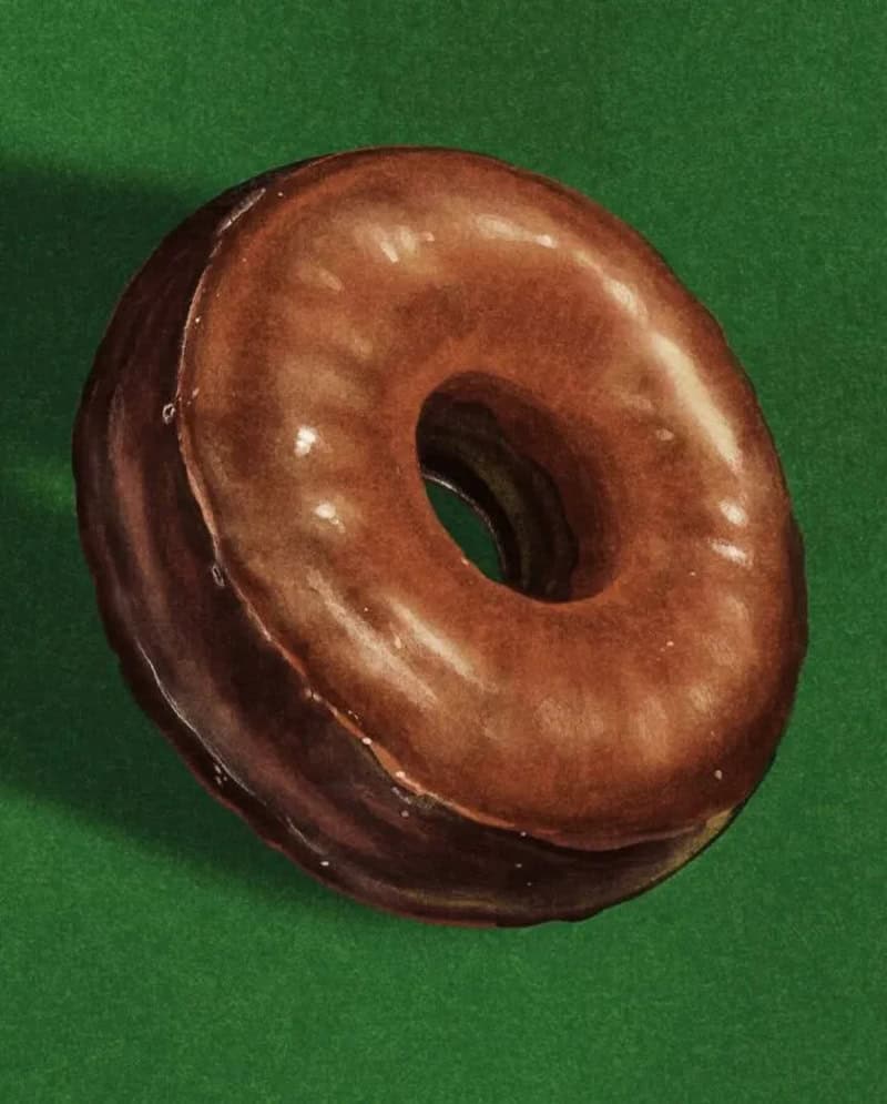 Chocolate glazed donut on green background.