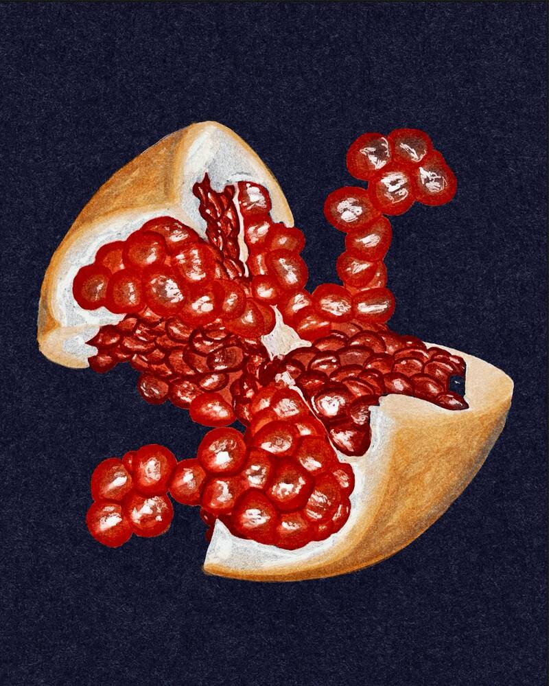 Pomegranate split open with seeds spilling out, on a dark background.