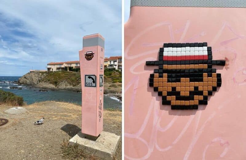 Pink street art pillar with a coffee cup sign and 'SOS' on the coast, and pixel art of a smiling man.