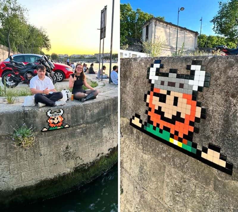 Two children sit by a river with pixel art of a Viking helmet and a character.