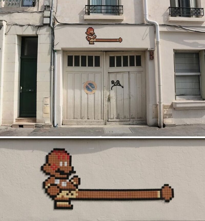 Street art mosaic of a pixelated character with a long nose on a garage door.