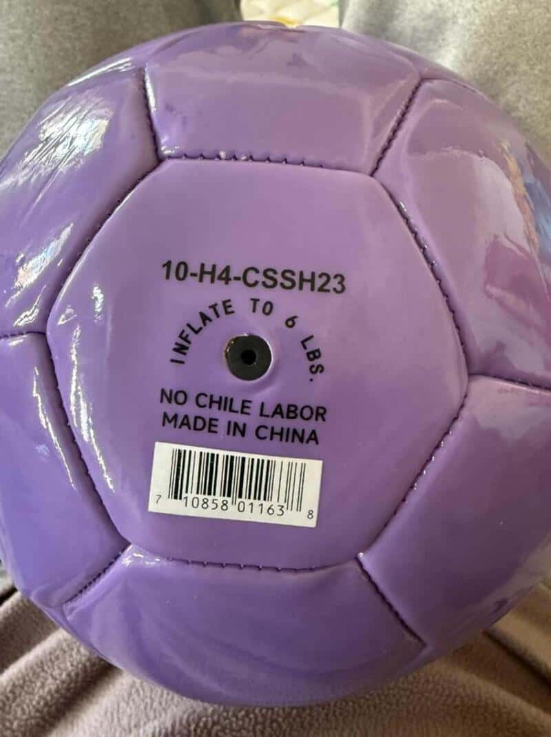 Purple soccer ball with label showing '10-H4-CSSH23' and 'NO CHILE LABOR MADE IN CHINA'.