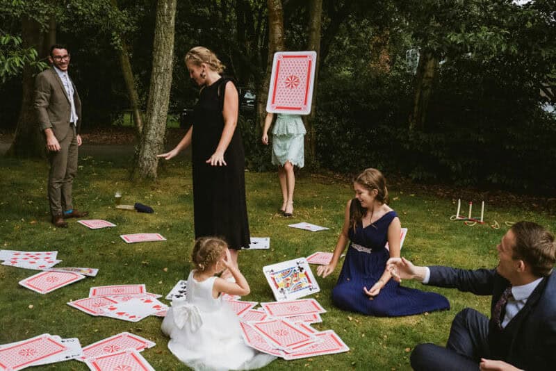 People playing a giant card game outdoors in a park.
