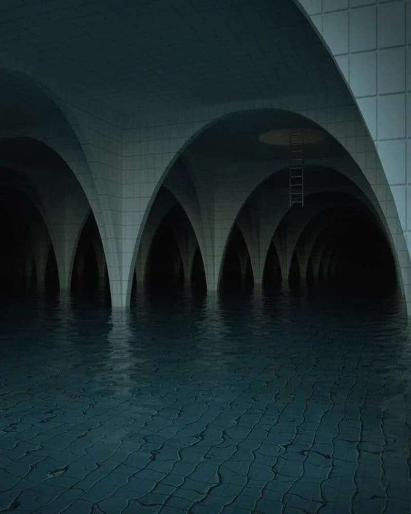 Underground tunnel with arched ceilings and water on the floor.