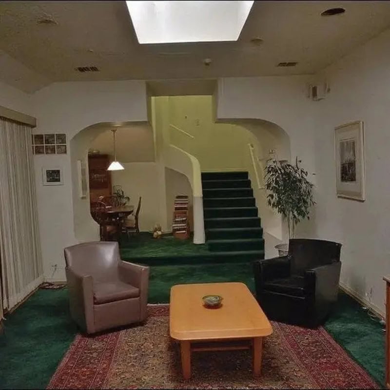 Living room with two armchairs, a coffee table, and a staircase in the background.