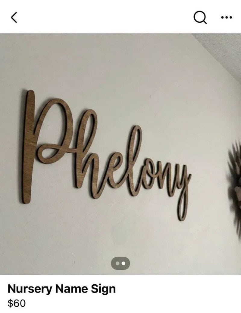 Wooden 'Hello' nursery sign on white wall.