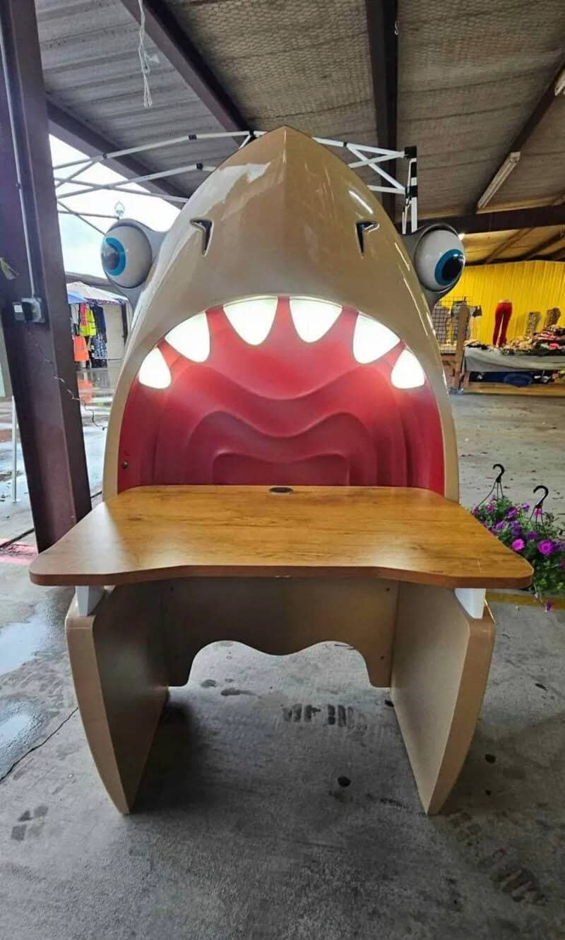 Shark-shaped chair with big eyes and an open mouth as a table.